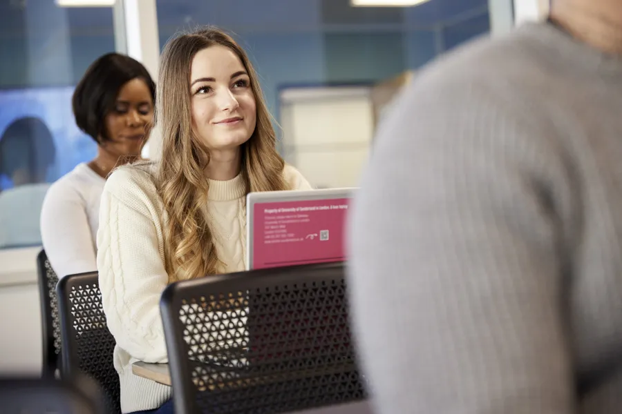 A student working at a laptop while listening during a lecture