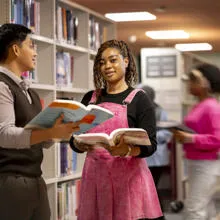students amongst bookshelves